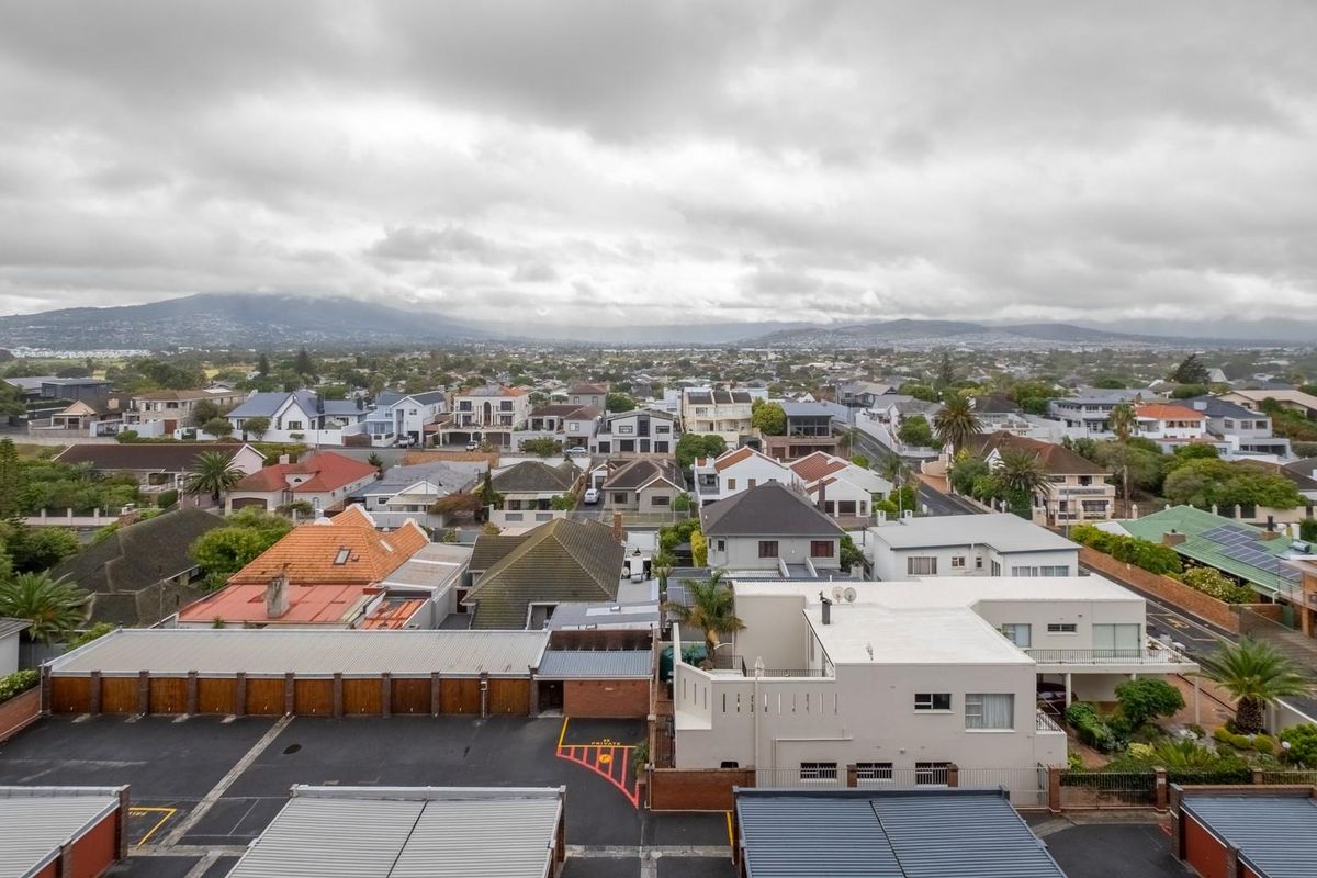 An elevated aerial view overlooking a residential neighborhood with a mix of suburban homes and apartment complex parking facilities.