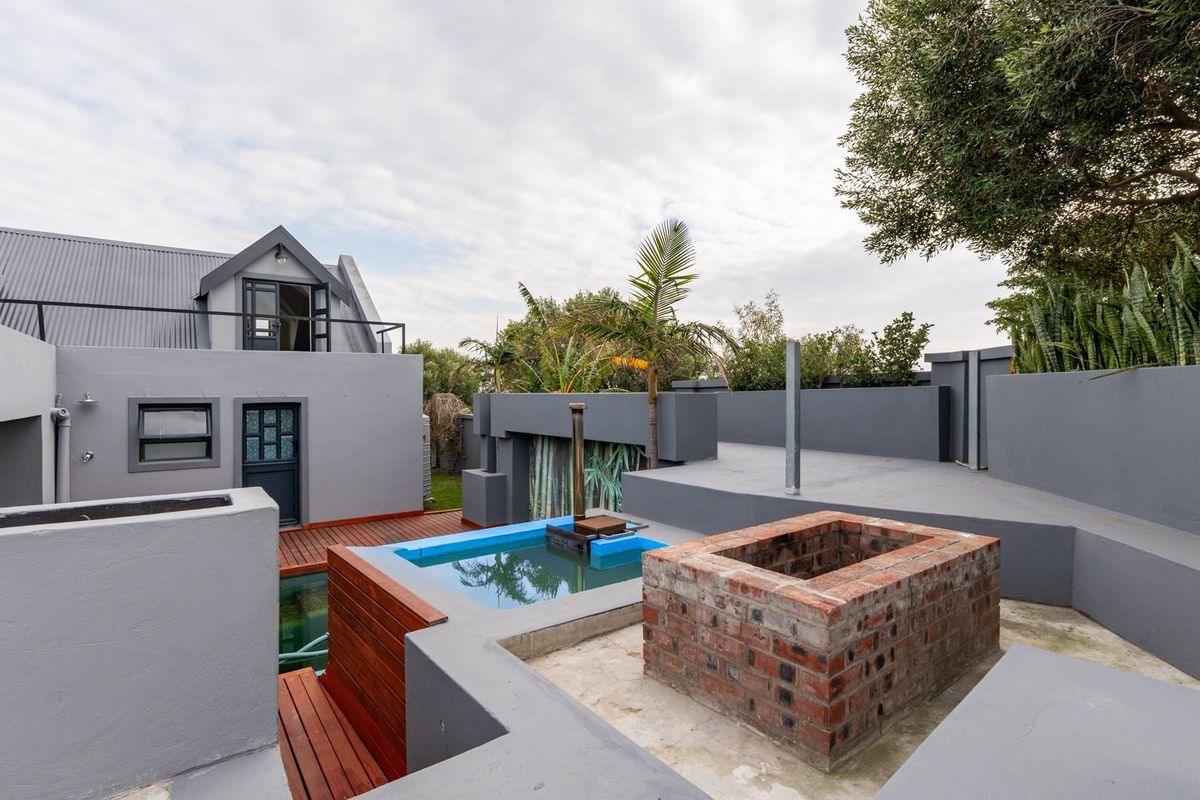 Rear exterior view featuring a multi-level patio, built-in brick fire pit, and a small plunge pool with timber decking.