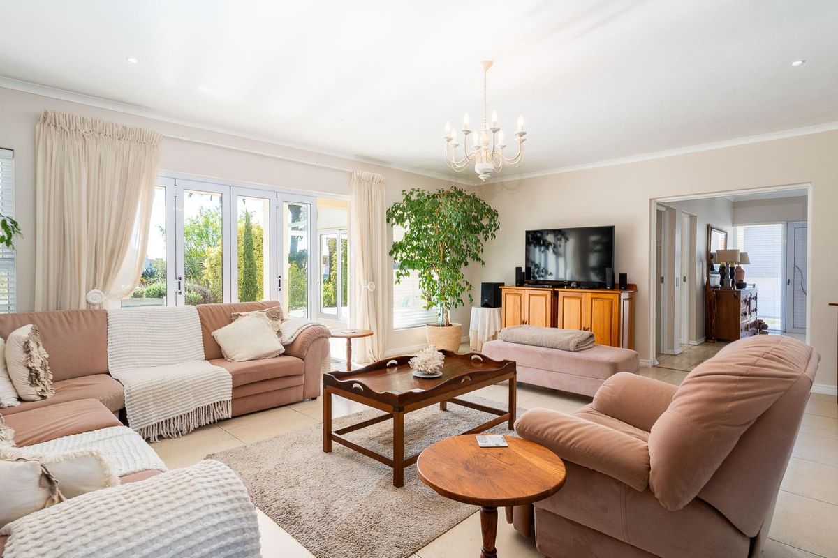 Spacious living room featuring tiled flooring, recessed ceiling lighting, and large glass sliding doors providing direct access to the outdoor patio area.