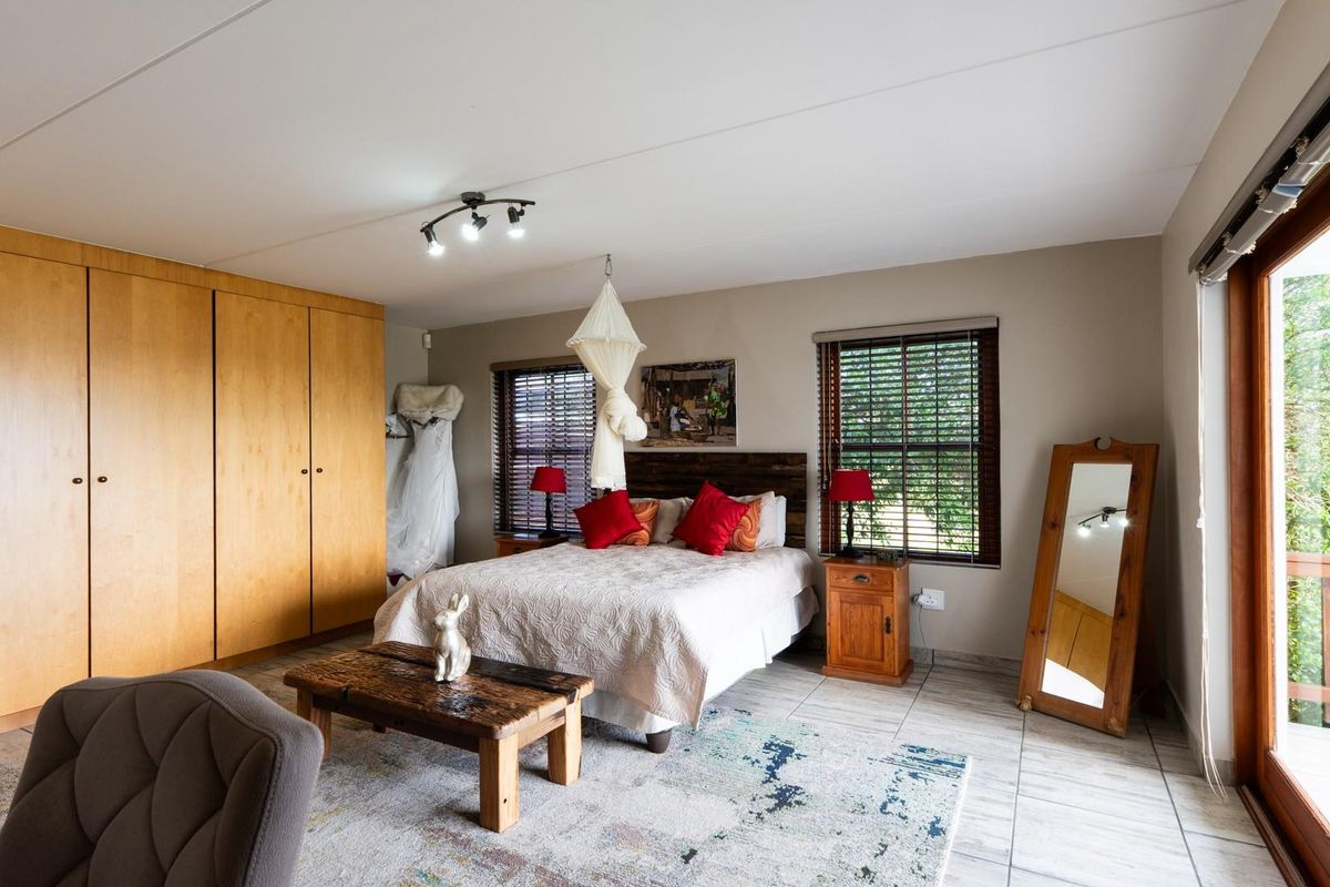 Spacious bedroom featuring built-in wooden cupboards, tiled flooring, and sliding glass doors providing access to an outdoor area.