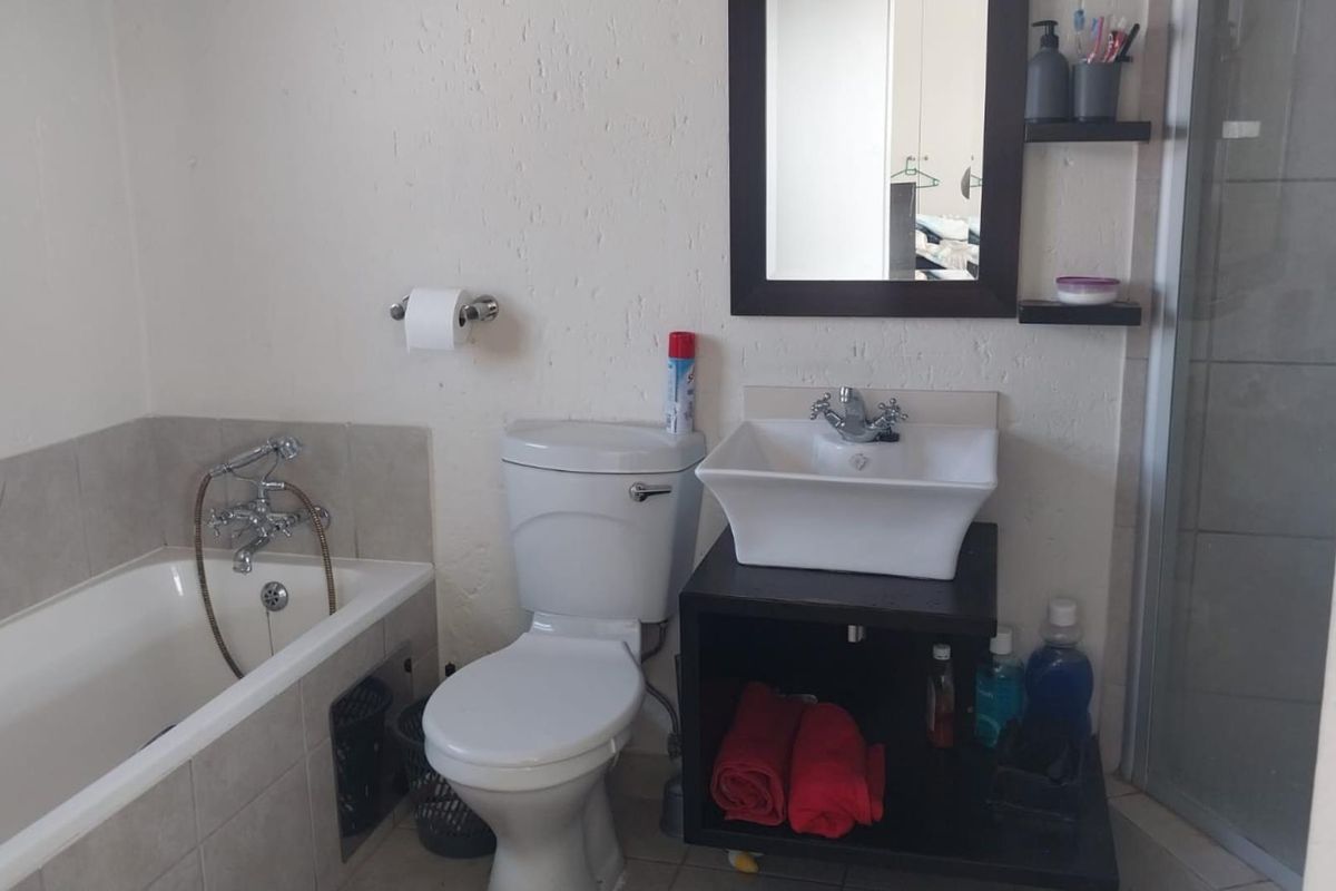 A functional bathroom featuring a built-in bathtub, a modern vessel sink vanity, a toilet, and a separate shower enclosure.