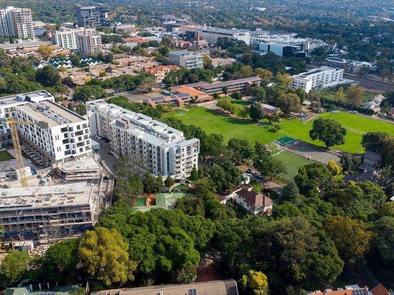 An aerial view of the residential land parcel, showcasing the surrounding neighborhood, mature trees, and proximity to local urban developments.