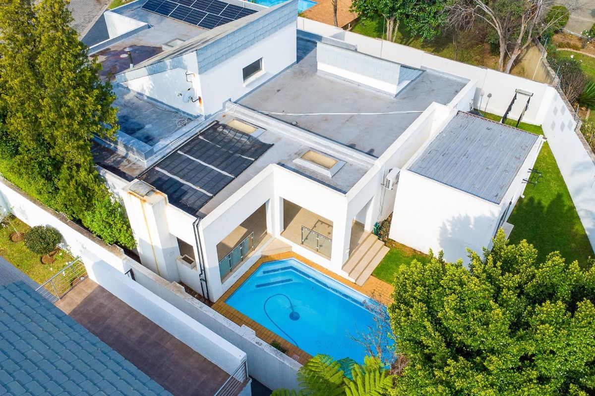 Aerial view of the townhouse property featuring a private swimming pool, patio area, and roof-mounted solar panels within a walled garden setting.