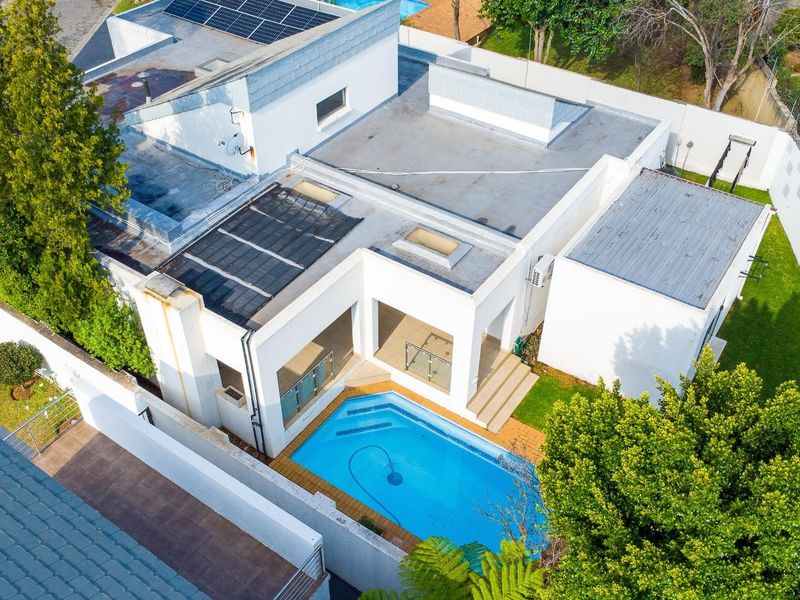 Aerial view of the townhouse property featuring a private swimming pool, patio area, and roof-mounted solar panels within a walled garden setting.