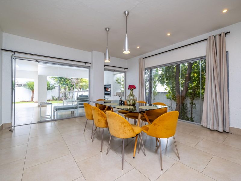 Bright and spacious dining area featuring large sliding glass doors that provide seamless access to the outdoor patio and garden.