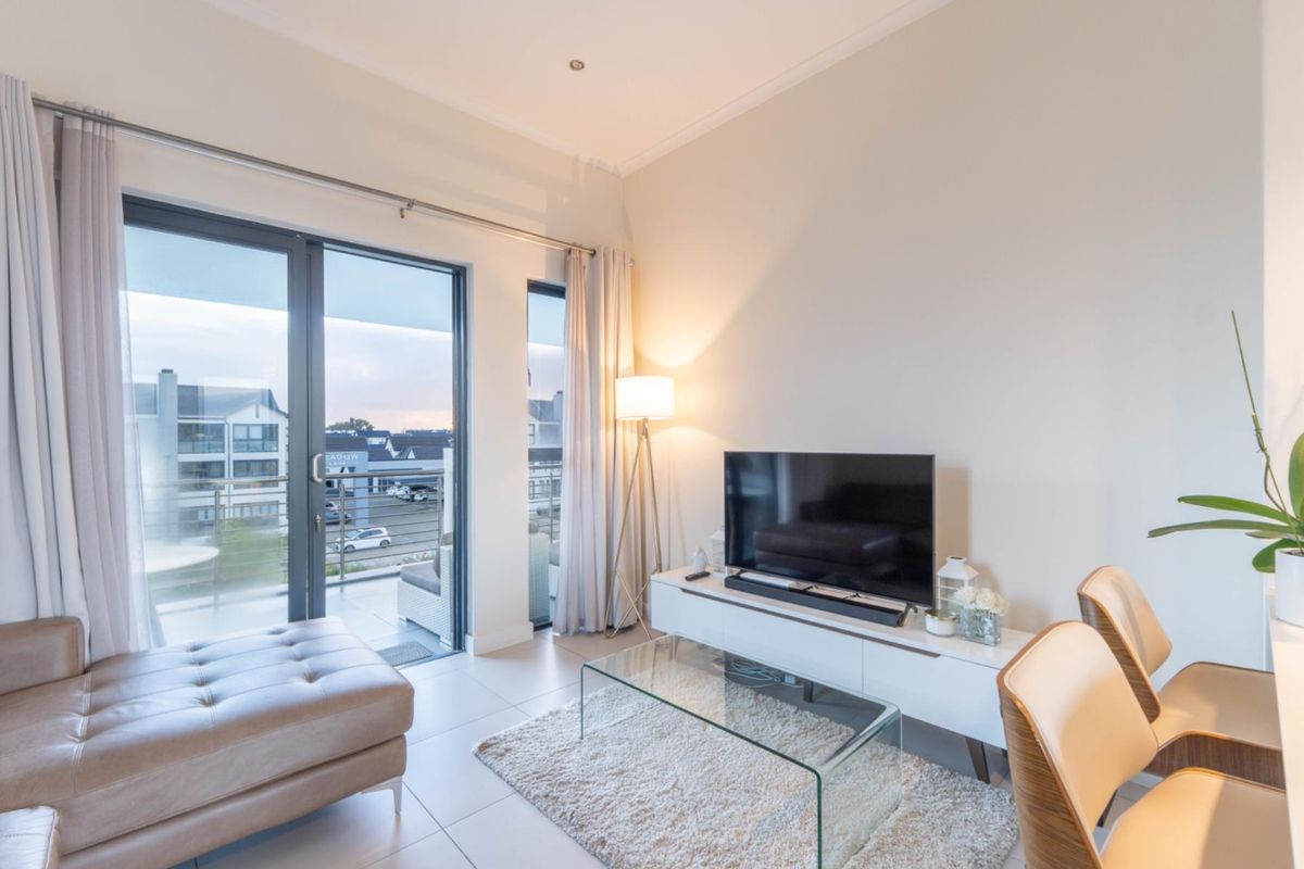 Bright living area featuring large glass sliding doors that open onto a private balcony, providing natural light and seamless indoor-outdoor flow.