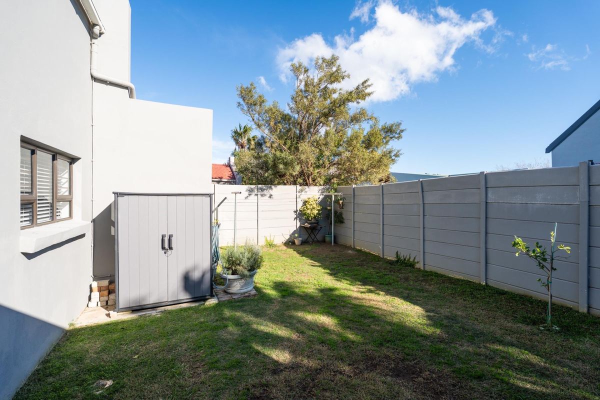 A private rear garden featuring a well-maintained lawn and secure precast concrete boundary walling, providing a clean and functional outdoor space.