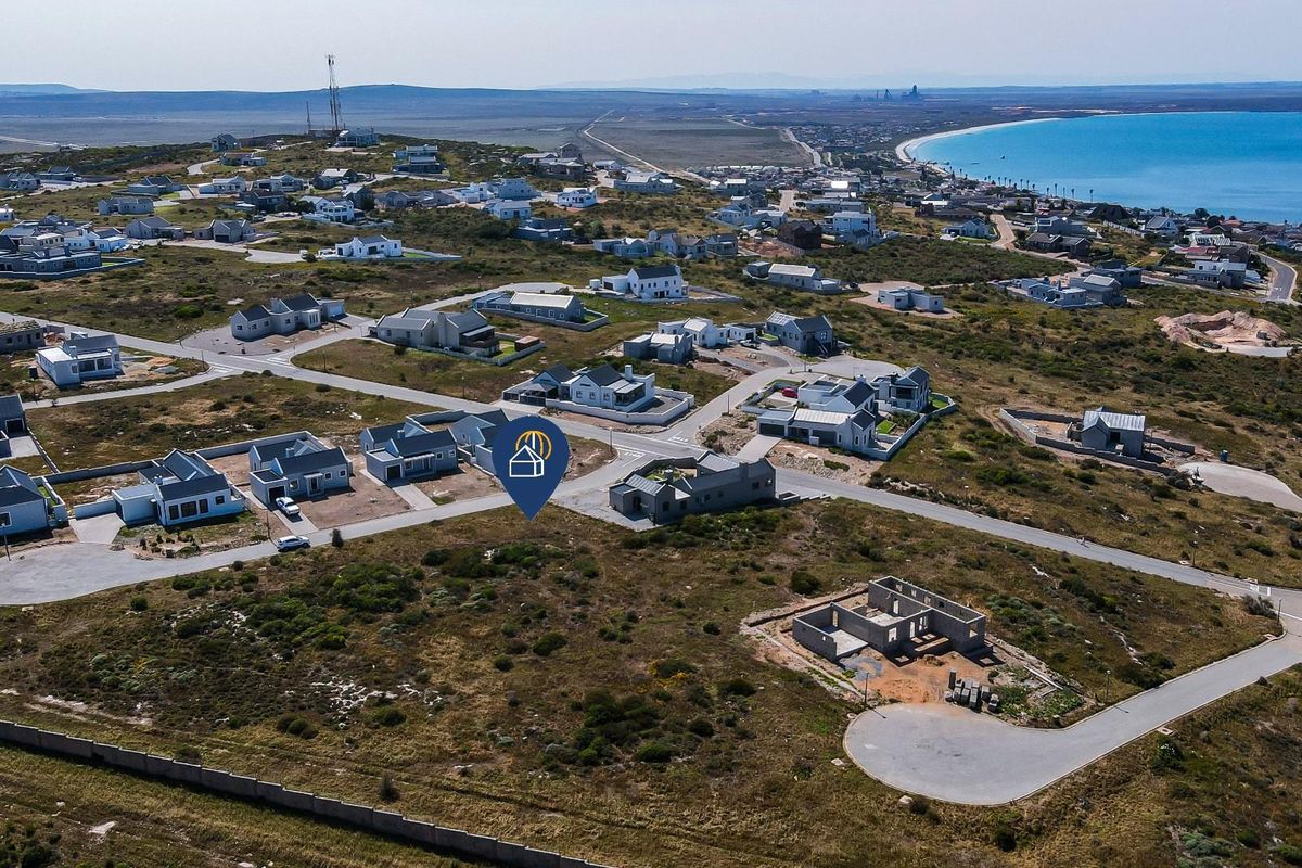 Aerial view of a residential estate development featuring paved roads and coastal proximity.