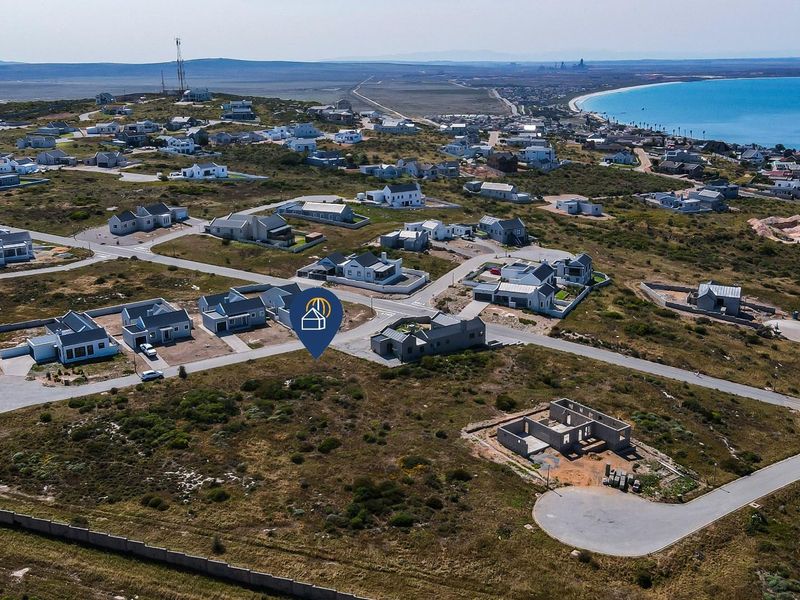 Aerial view of a residential estate development featuring paved roads and coastal proximity.