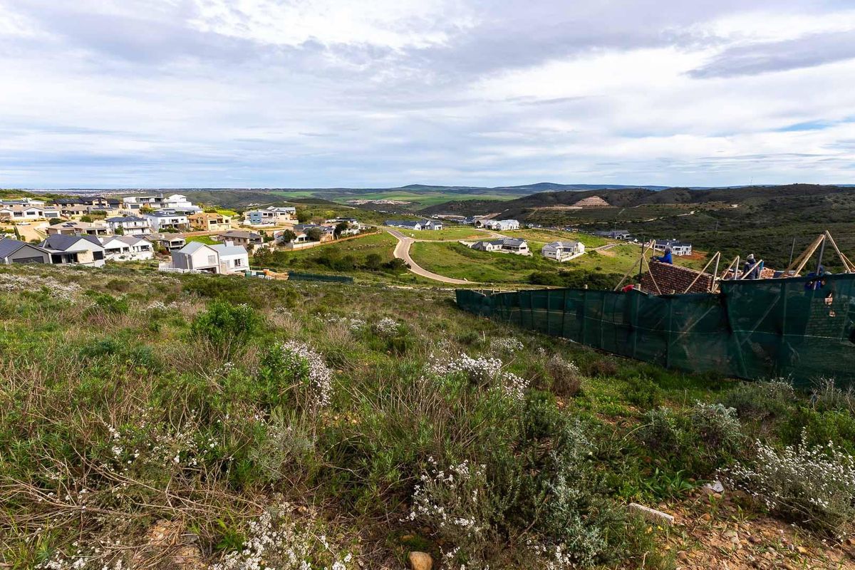 An elevated view overlooking a residential estate and surrounding natural landscape, showcasing the development potential of the vacant land.