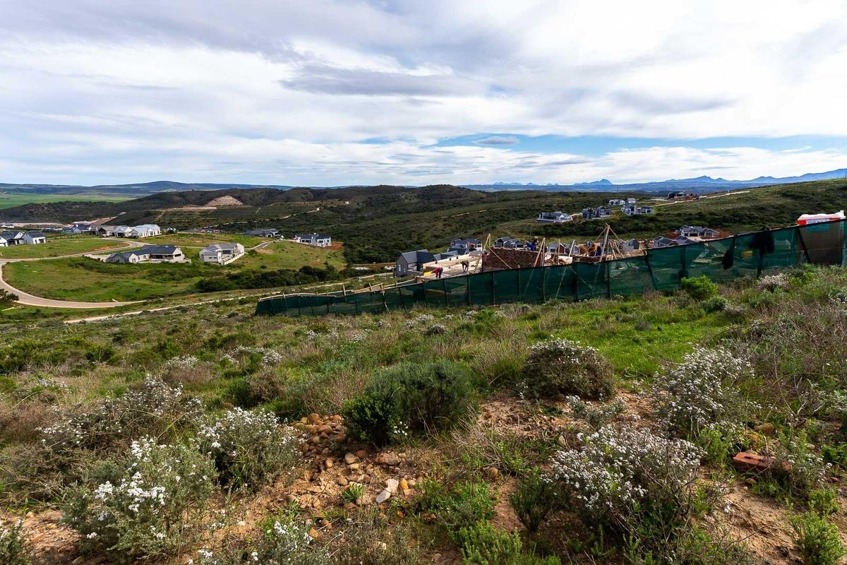 An elevated view of a residential development site featuring ongoing construction work and surrounding landscape.