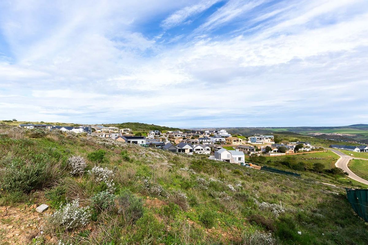 A wide-angle view of the surrounding residential estate and natural landscape, showcasing the elevated position of the vacant land.