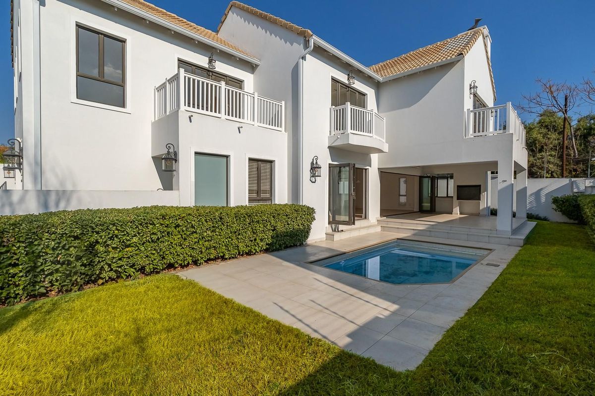 Rear view of the property featuring a tiled patio, a private swimming pool, landscaped garden, and multiple upper-level balconies.