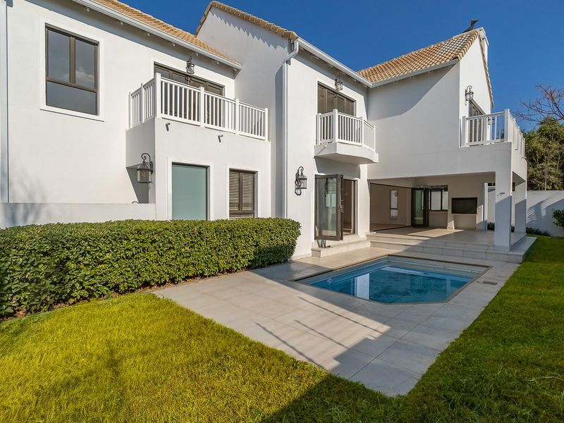 Rear view of the property featuring a tiled patio, a private swimming pool, landscaped garden, and multiple upper-level balconies.