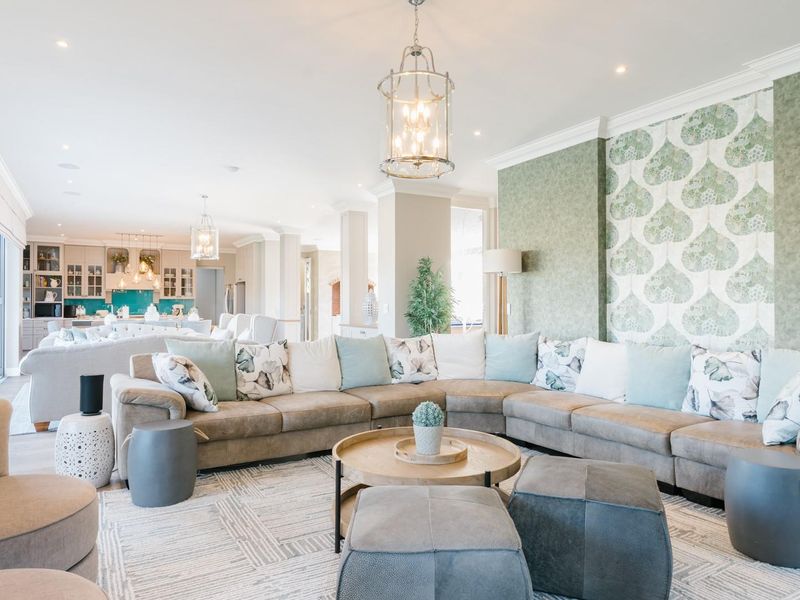 Spacious open-plan living area featuring elegant crown molding, recessed lighting, and a seamless transition to the kitchen, complemented by large sliding glass doors.