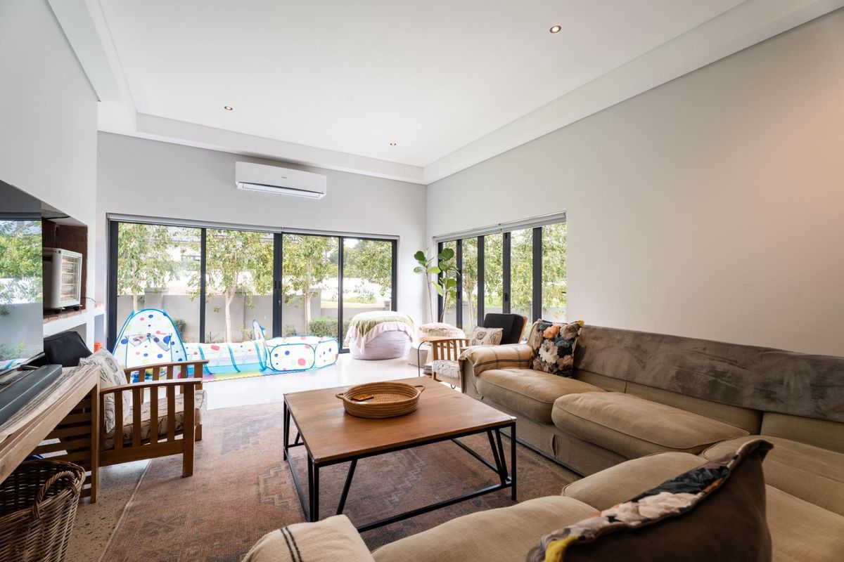 Spacious living room featuring large aluminium sliding doors that provide ample natural light and direct access to the outdoor area.