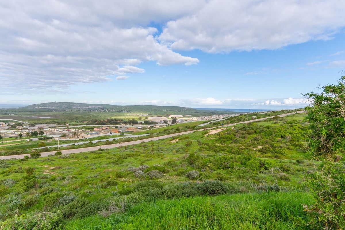 A wide-angle view of the vacant residential land, showcasing the surrounding landscape, natural vegetation, and distant coastal scenery.