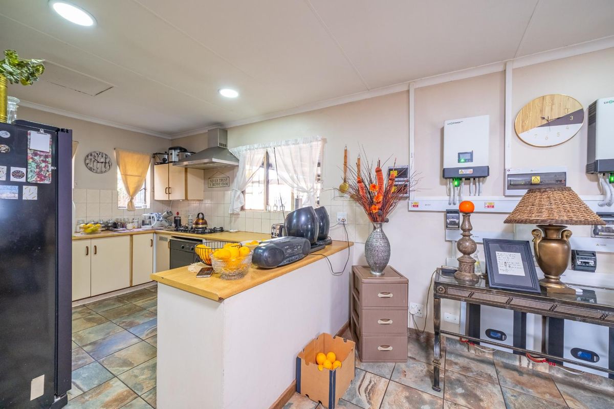 Functional kitchen featuring tiled flooring, built-in cabinetry, and a gas hob, with an integrated inverter system installed on the wall.