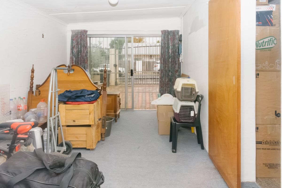 A bedroom featuring carpet flooring, a built-in cupboard, and a sliding glass door providing access to the exterior.