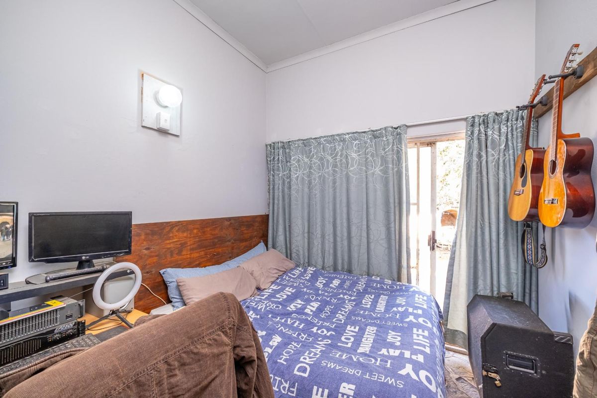 A bedroom featuring a wooden headboard and a sliding glass door providing access to the exterior.