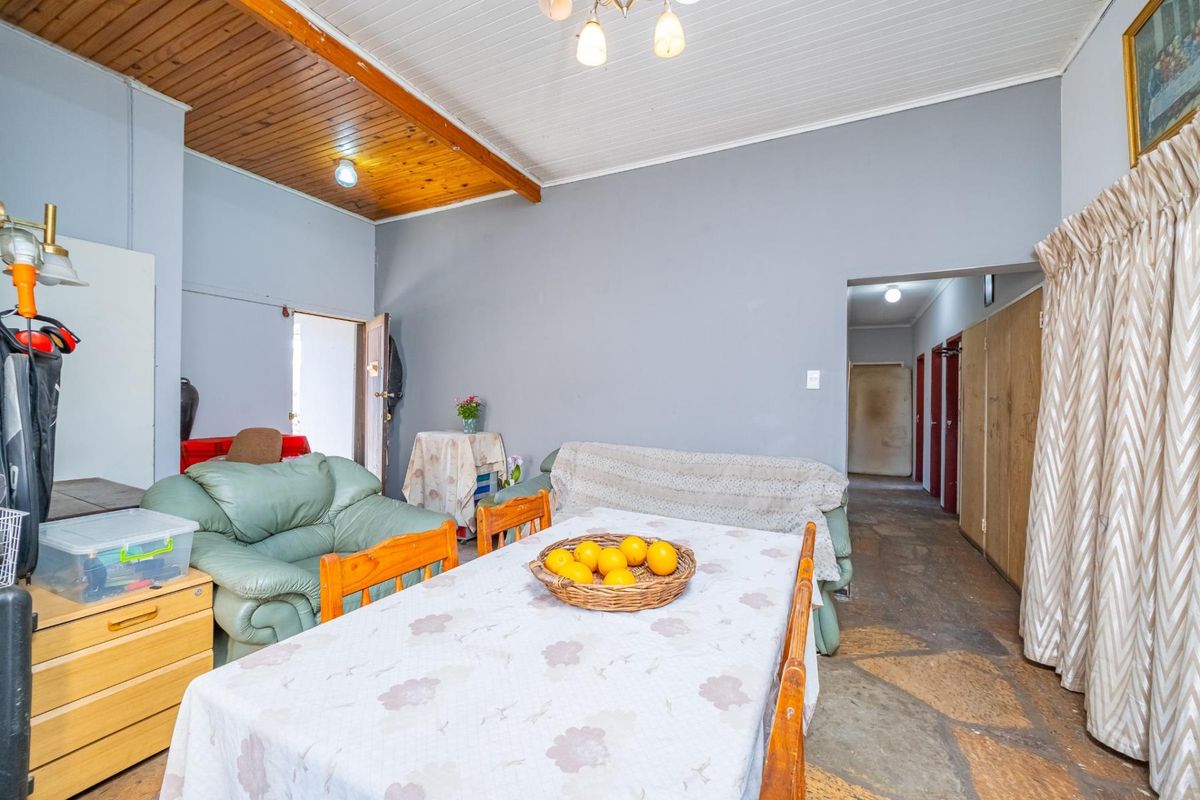 Living area featuring a combination of timber and painted ceilings with rustic stone flooring and built-in storage cupboards.