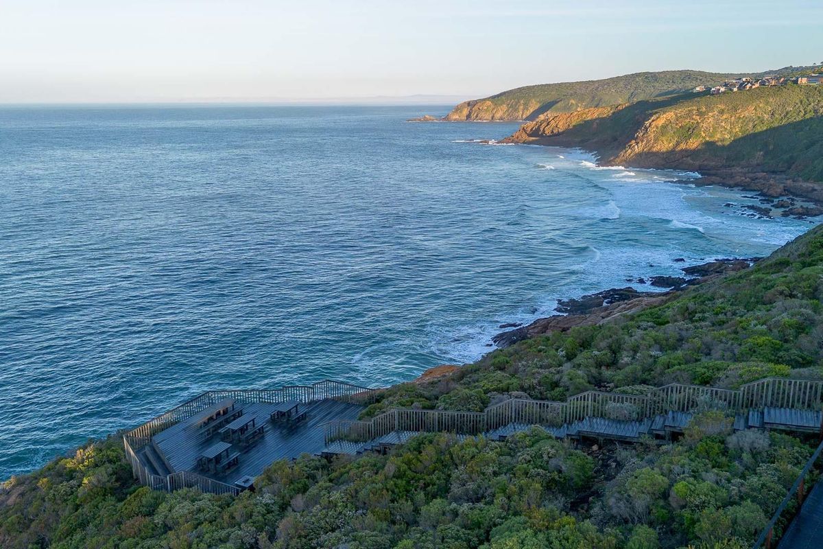 Stunning elevated coastal view featuring a timber viewing deck and staircase integrated into the natural landscape overlooking the ocean.