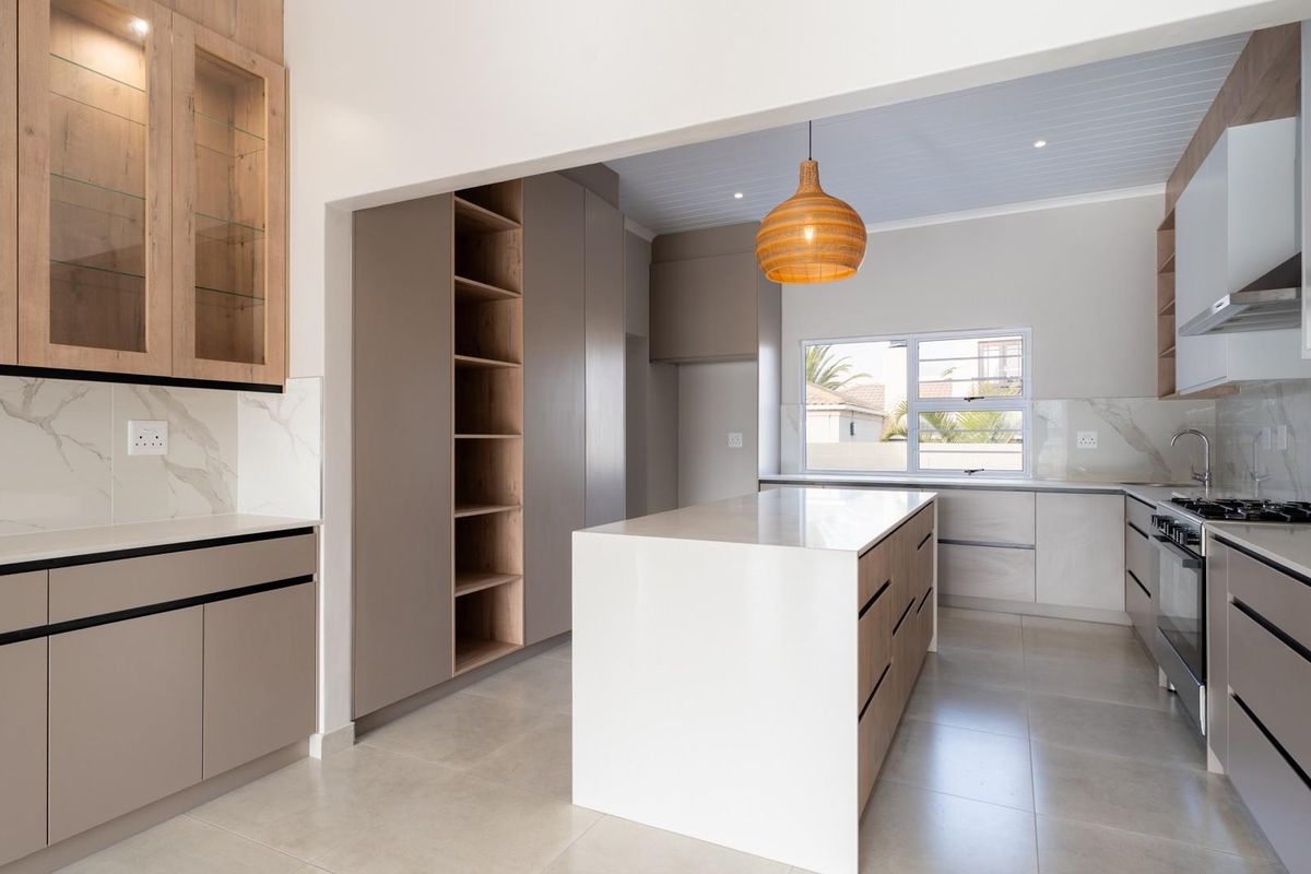 Modern, well-appointed kitchen featuring a central island, quartz countertops, marble-look backsplash, and integrated cabinetry with high-quality finishes.