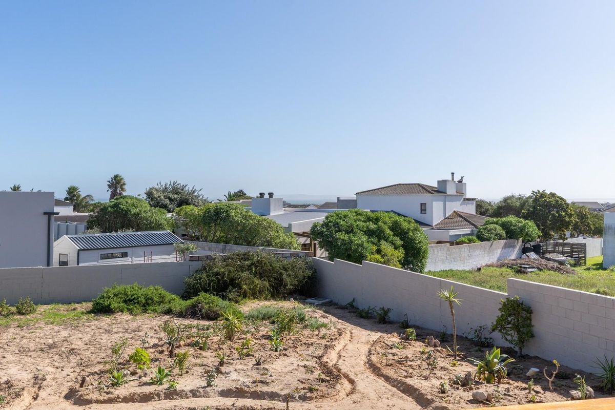 A view of the rear garden area featuring a boundary wall and established landscaping, overlooking the surrounding residential neighbourhood.