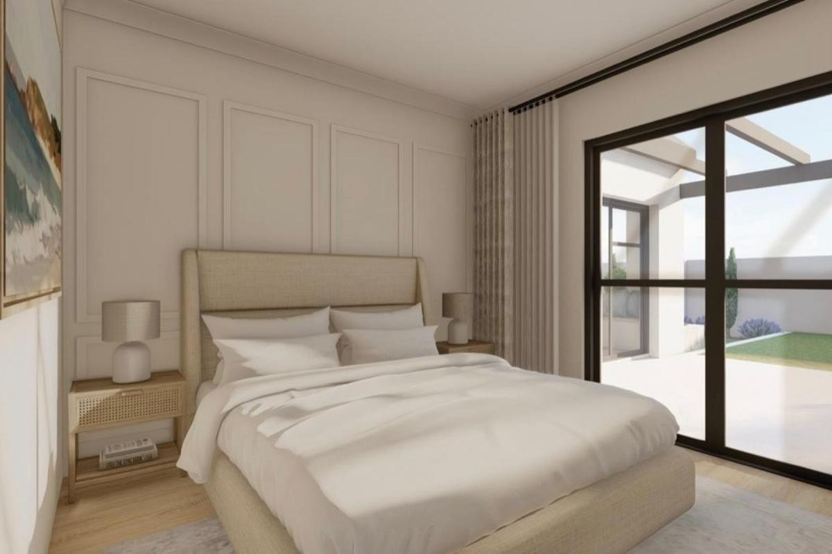 A modern bedroom featuring elegant wainscoting, hardwood flooring, and large sliding glass doors that provide seamless access to the outdoor patio area.