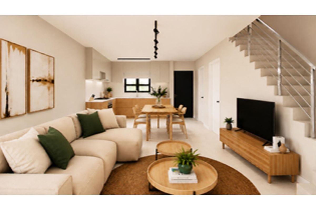 Modern open-plan living area featuring a sleek kitchen, dining space, and a staircase with a contemporary metal balustrade.
