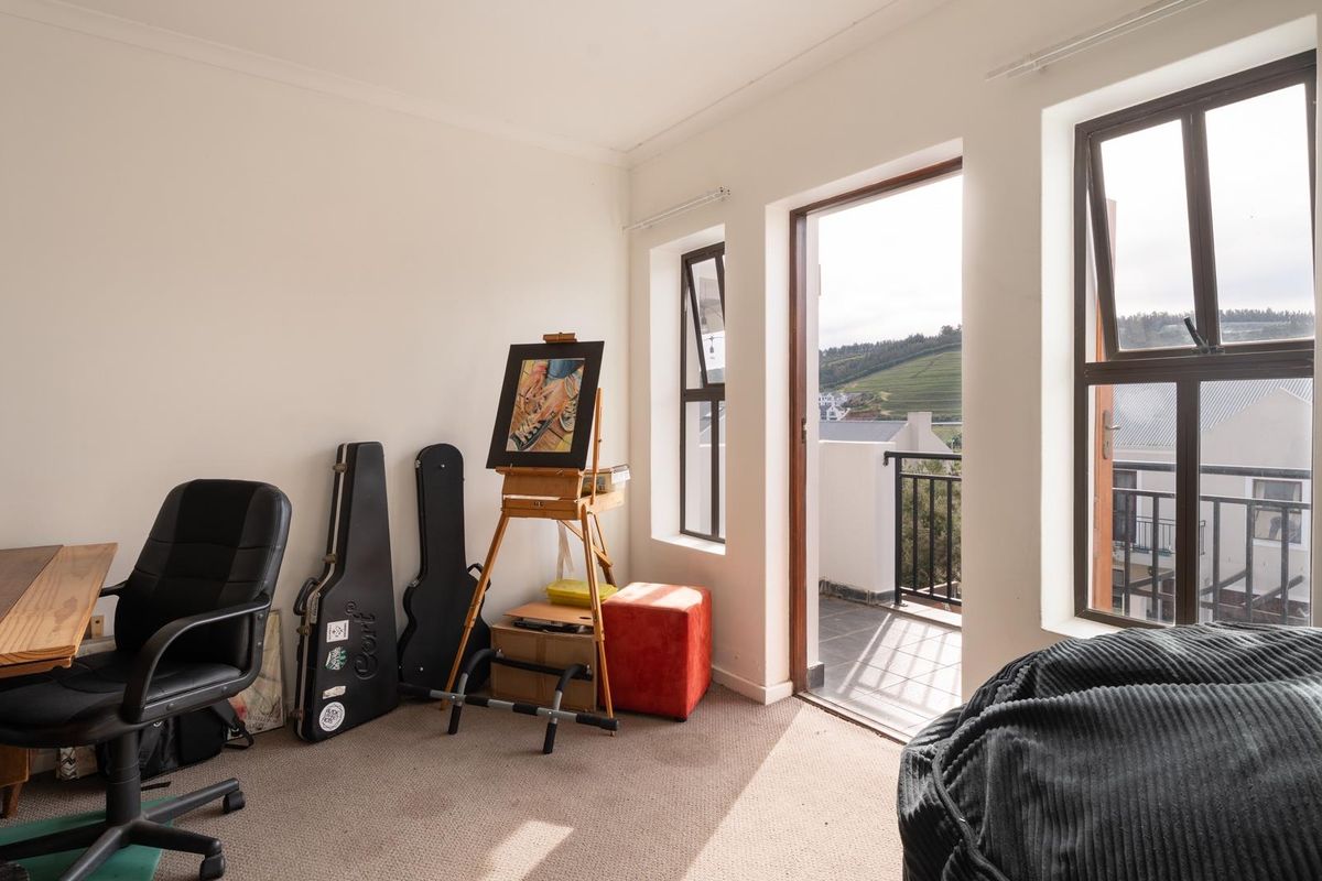 A bedroom featuring carpeted flooring and direct access to a private balcony through a sliding door, offering natural light and outdoor views.