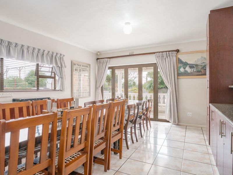 Spacious dining area featuring tiled flooring, built-in cabinetry with granite countertops, and sliding glass doors providing access to the outdoor patio.