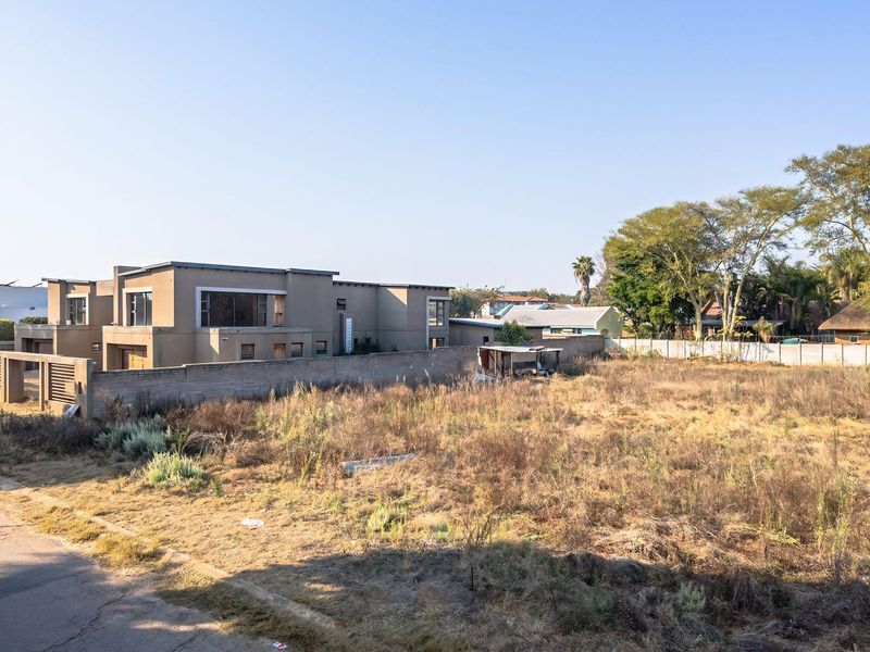 A vacant residential plot featuring level ground, boundary walling, and direct street access, situated in an established neighbourhood.