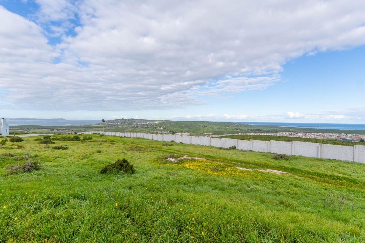 Expansive view of the vacant residential land featuring a perimeter boundary wall and surrounding coastal landscape.