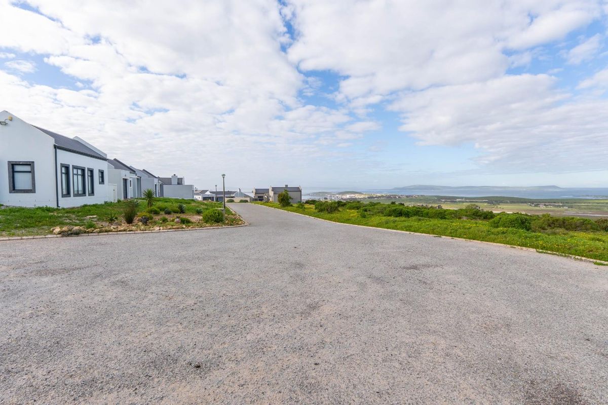 A view of the gravel street and surrounding coastal landscape in a residential estate.