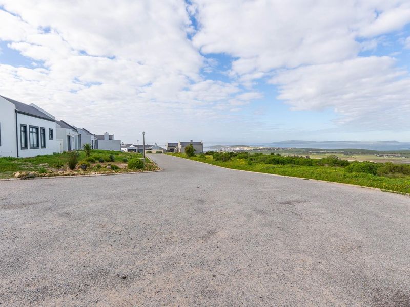 A view of the gravel street and surrounding coastal landscape in a residential estate.
