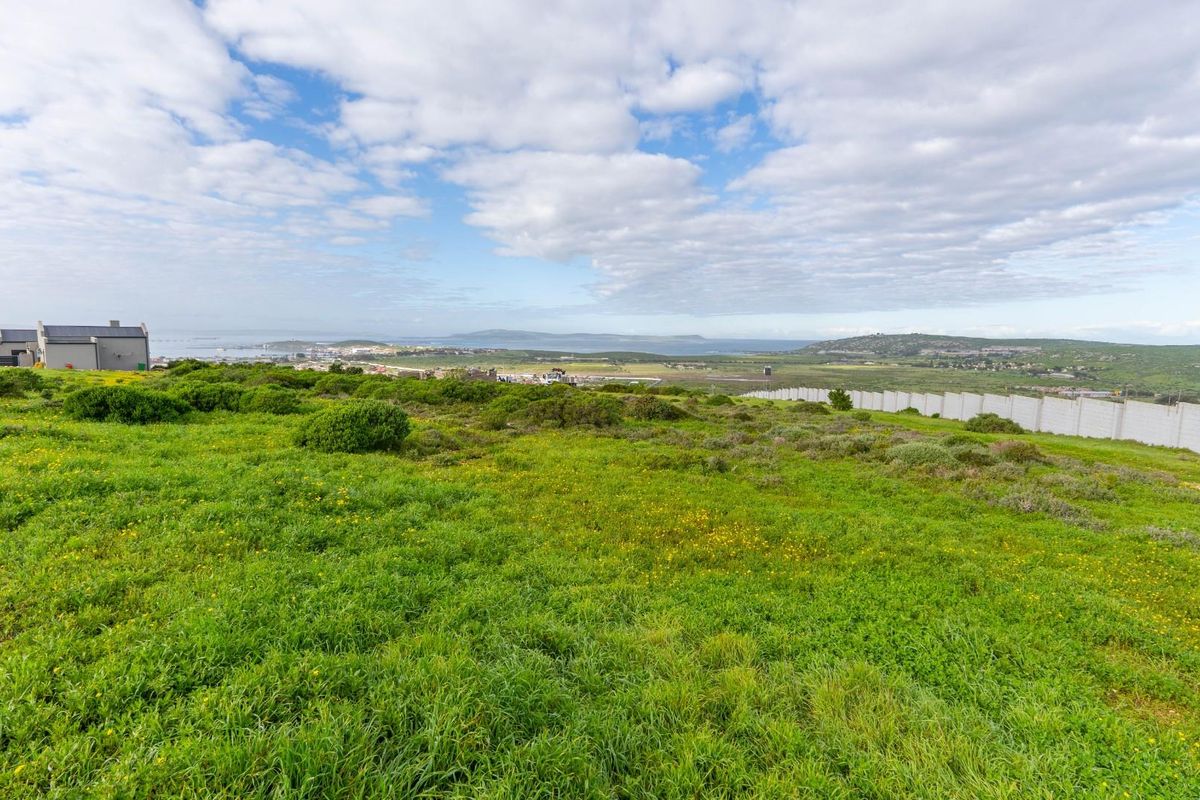 Expansive view of the surrounding landscape and coastline from the vacant residential plot, featuring a perimeter boundary wall.
