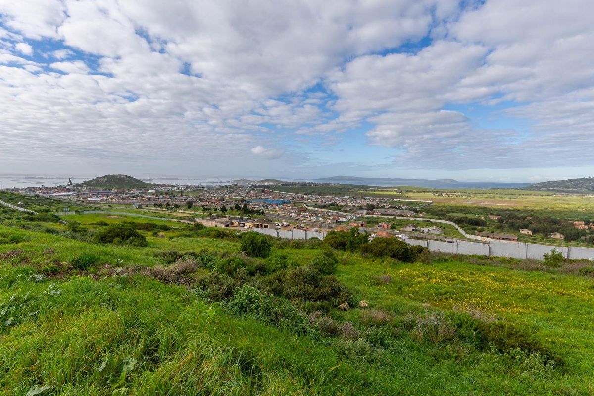 Expansive elevated view overlooking the surrounding residential landscape and distant coastal terrain from the vacant residential plot.