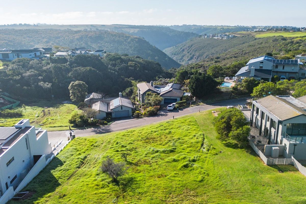Aerial view of a vacant residential plot situated within a developed estate, featuring surrounding greenery and established neighborhood infrastructure.