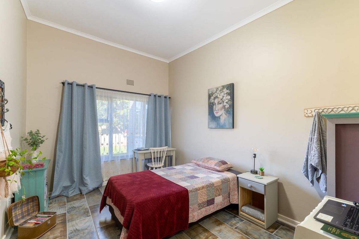 A well-lit bedroom featuring tiled flooring and neutral wall finishes, providing a comfortable and functional living space.