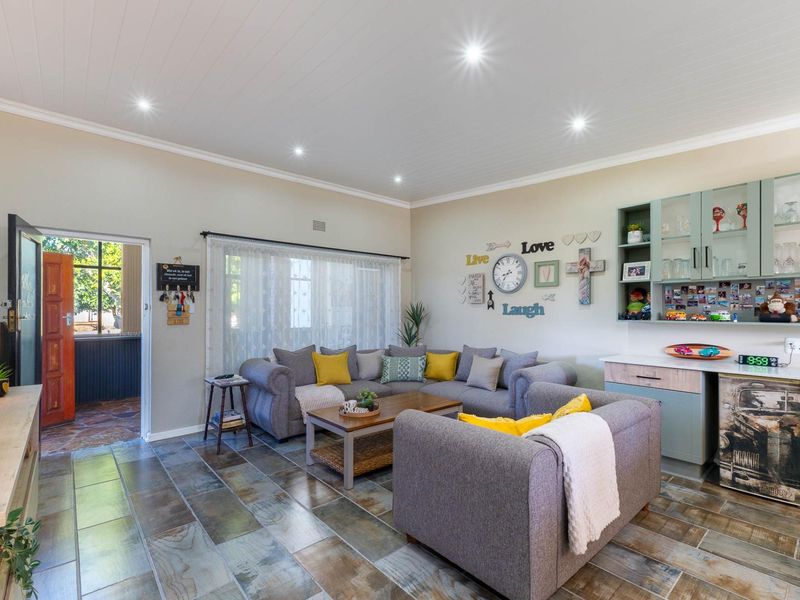 A comfortable living room featuring tiled flooring, a tongue and groove ceiling with recessed lighting, and built-in cabinetry for storage.