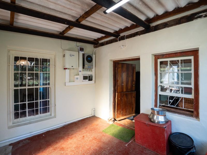 Utility space featuring exposed timber rafters, solar power infrastructure, and timber sash windows, providing a functional area for home energy management.