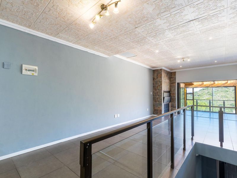 Spacious open-plan living area featuring tiled floors, a unique textured ceiling, a built-in stone fireplace, and large sliding doors leading to a balcony.