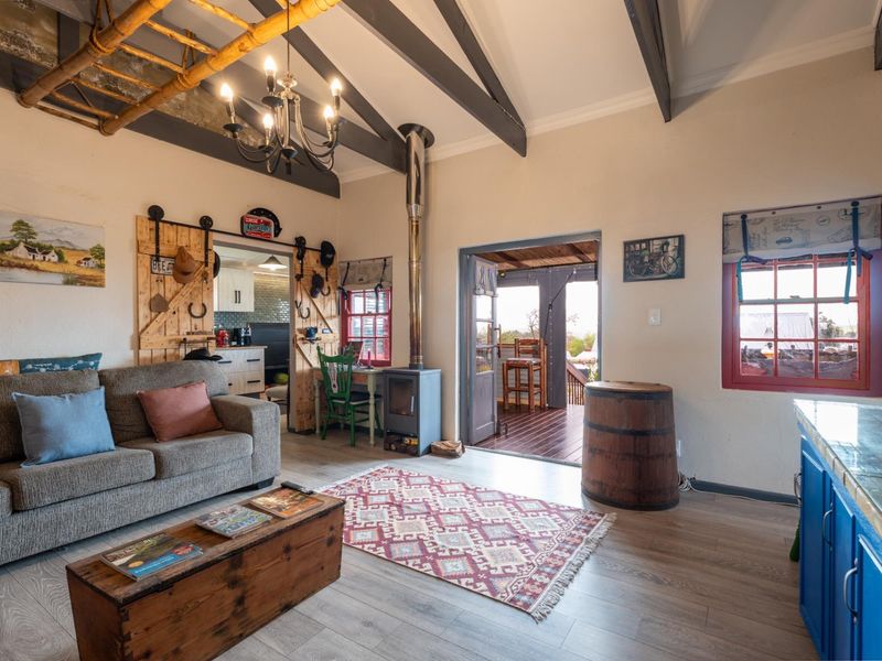 Cozy living room featuring exposed timber ceiling beams, a freestanding wood-burning fireplace, and sliding barn-style doors leading to an adjacent space.