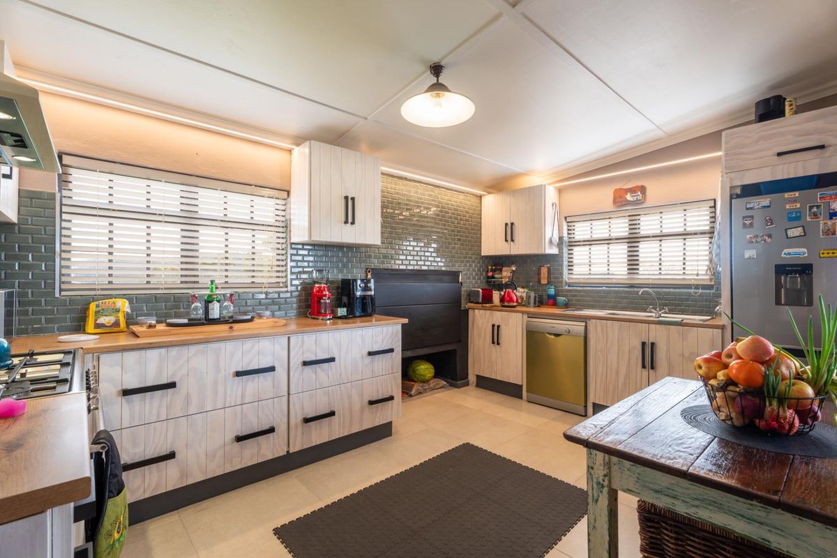 Modern kitchen featuring light wood-grain cabinetry, subway tile backsplash, integrated indoor braai, and functional workspace with ample storage.
