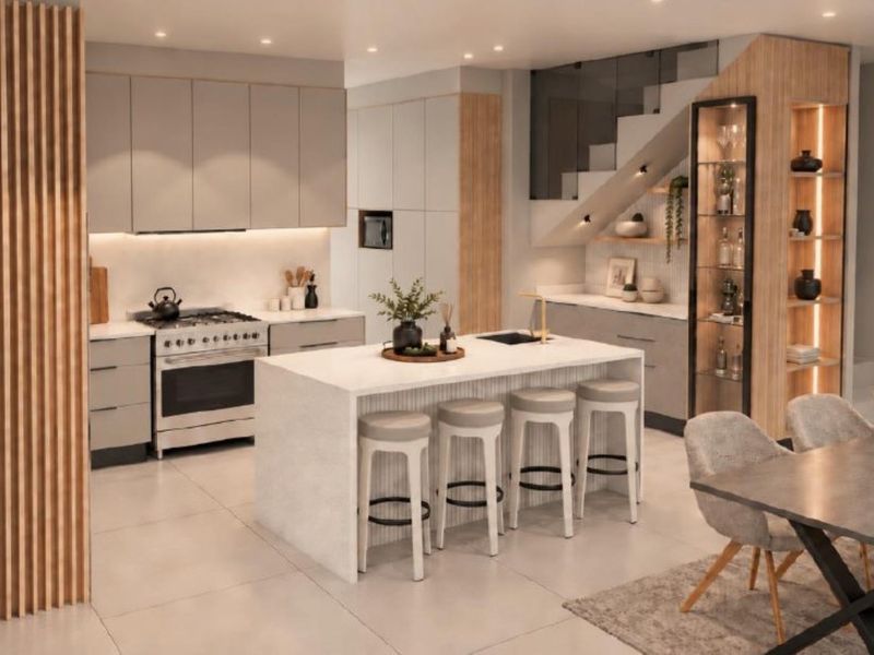 Modern open-plan kitchen featuring a central island, sleek cabinetry, integrated display shelving, and a stylish staircase, creating a sophisticated and functional living space.