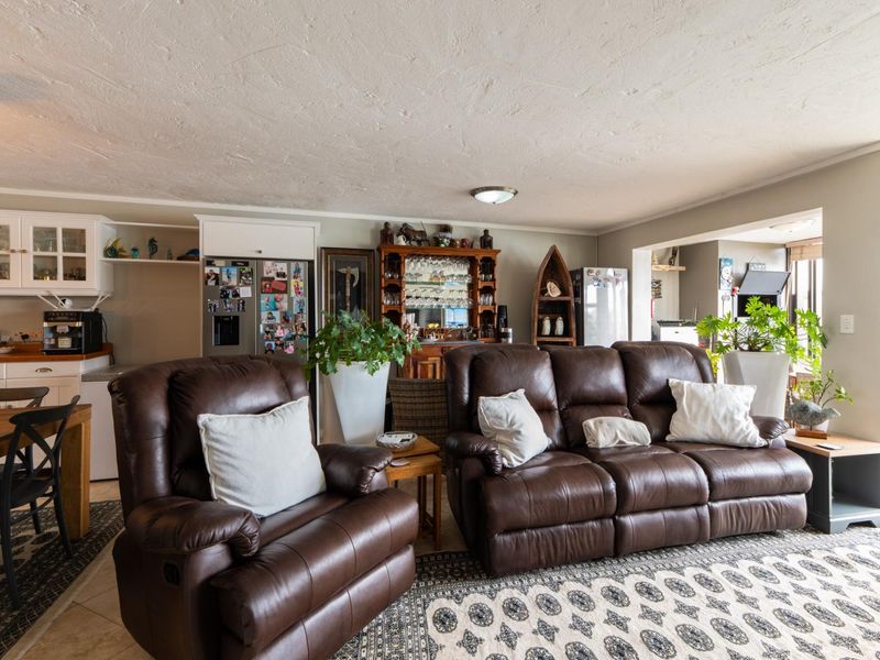 Open plan living and kitchen area featuring tiled flooring and built-in cabinetry, providing a functional and connected space for daily living.
