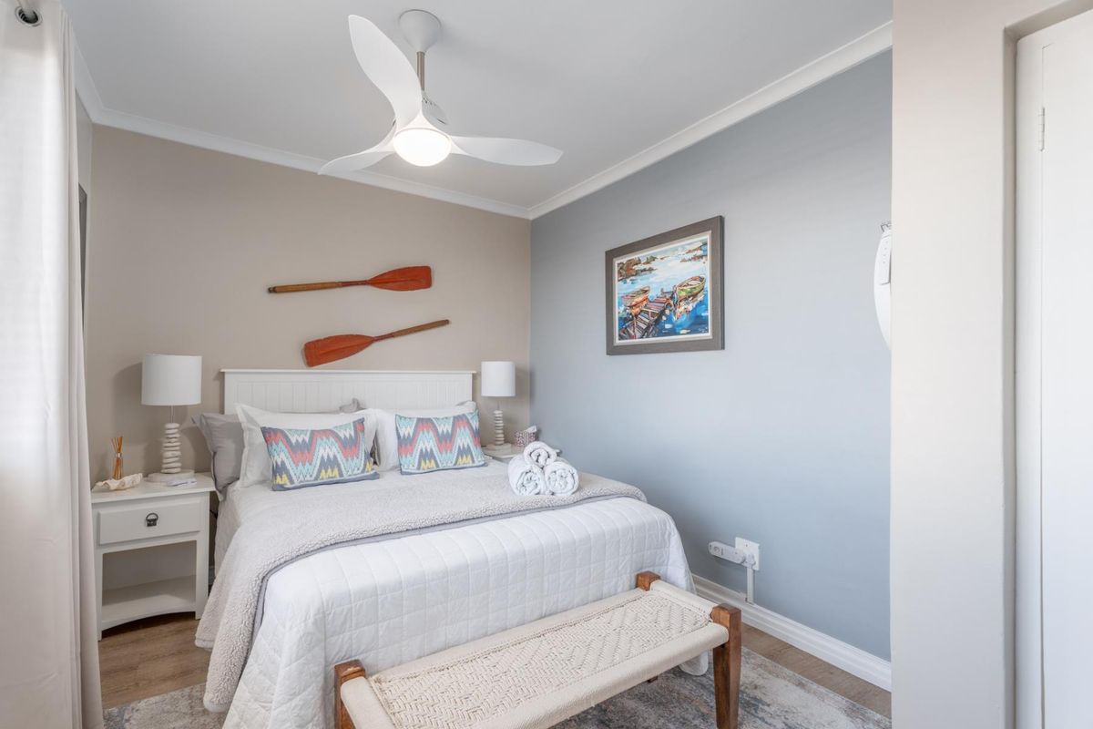 A well-maintained bedroom featuring a modern ceiling fan, neutral wall tones, and clean finishes throughout.