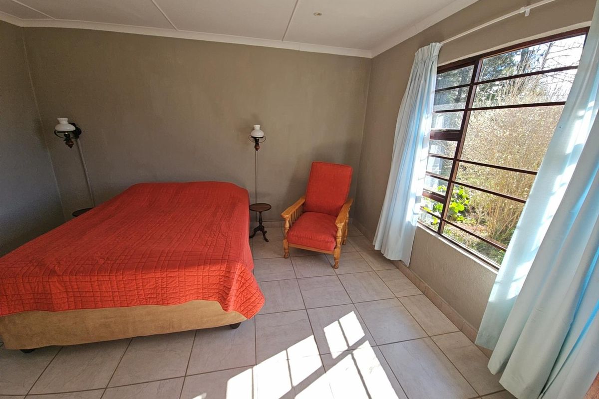 A bedroom featuring tiled flooring, large windows allowing natural light, and recessed ceiling lighting.