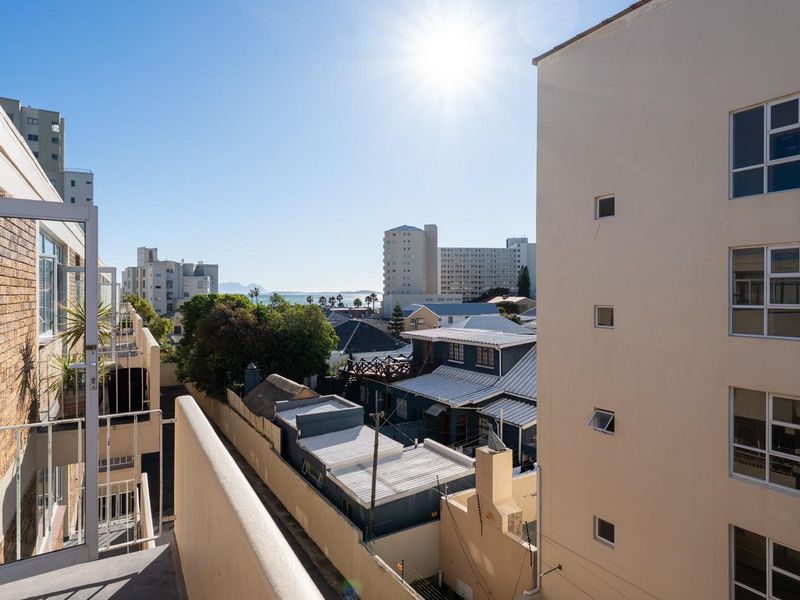 An elevated view from an apartment balcony overlooking the surrounding neighbourhood and distant coastal skyline.